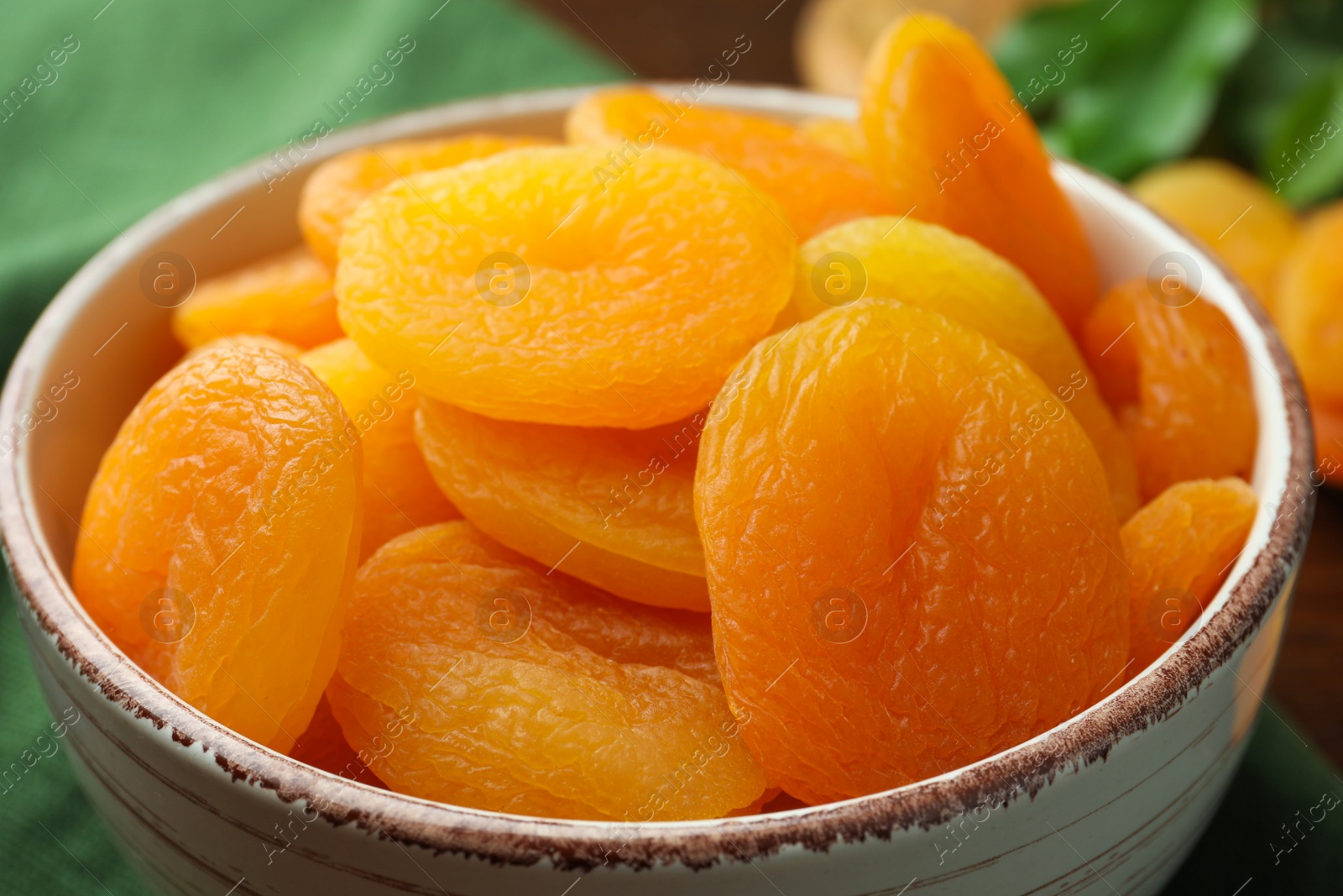 Photo of Closeup view of tasty apricots in bowl. Dried fruits