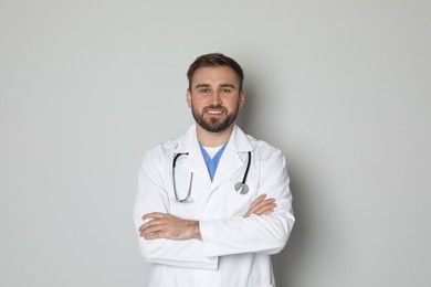 Portrait of young doctor on light grey background