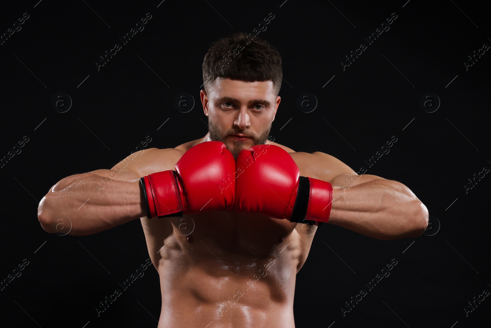 Photo of Man in boxing gloves on black background