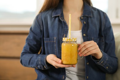 Woman with delicious smoothie indoors, closeup view