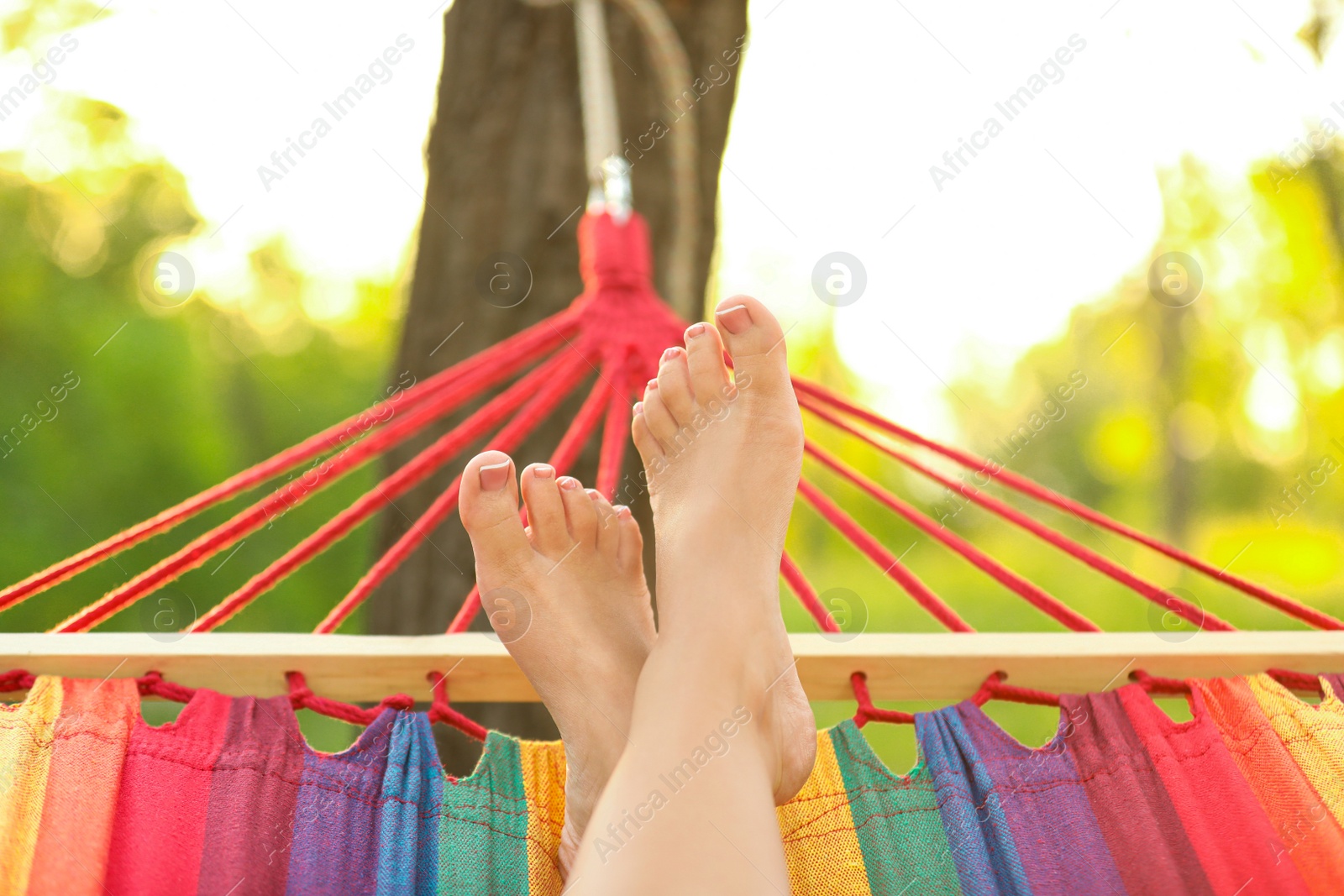 Photo of Woman resting in comfortable hammock at green garden, closeup