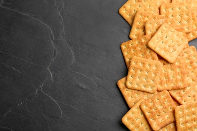 Photo of Many delicious crackers on black table, flat lay. Space for text