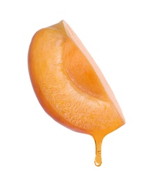 Image of Apricot oil dripping from fresh cut fruit on white background