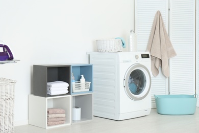 Photo of Washing of different towels in modern laundry room