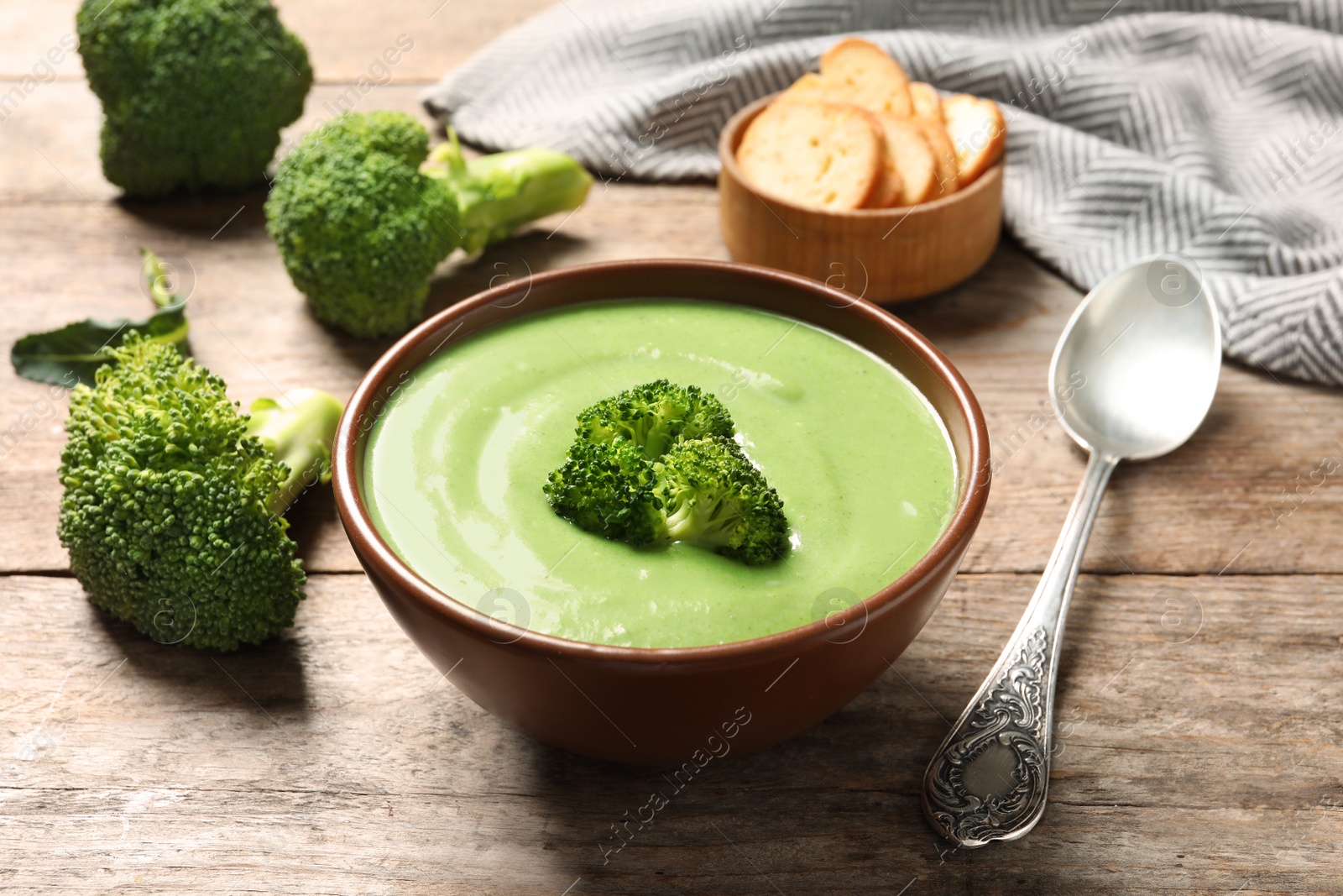 Photo of Fresh vegetable detox soup made of broccoli served on wooden table