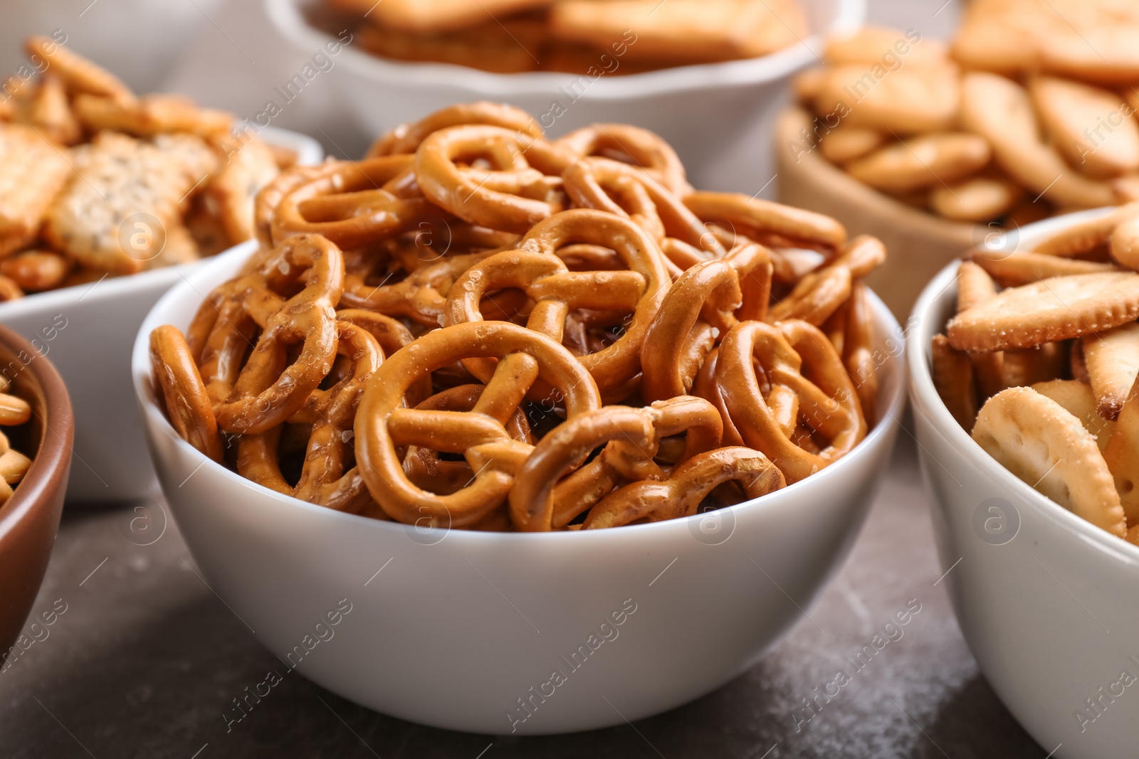 Photo of Delicious crackers in bowls on table, closeup