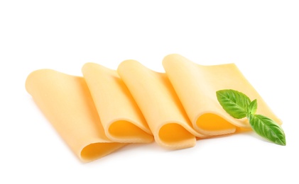 Slices of tasty cheese with basil on white background