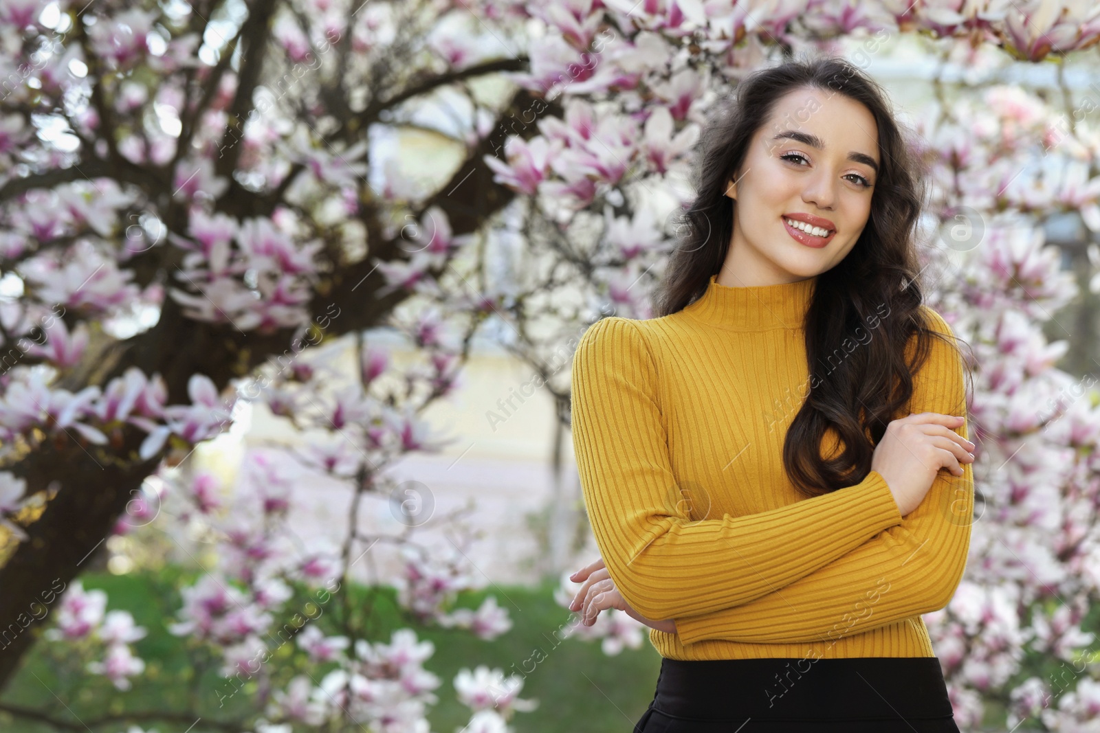 Photo of Beautiful woman near blossoming magnolia tree on spring day