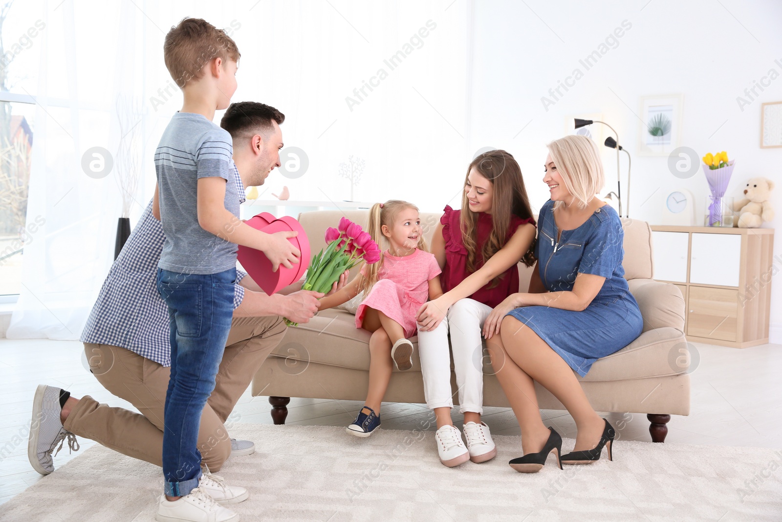 Photo of Man and little boy congratulating women at home