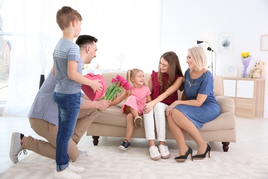 Photo of Man and little boy congratulating women at home