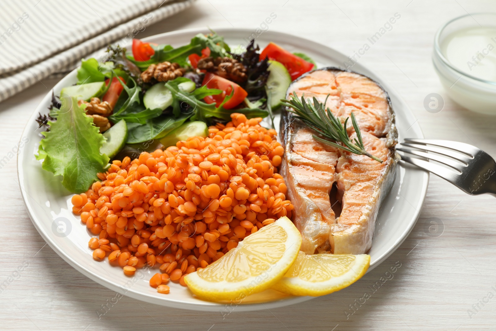 Photo of Plate with healthy food high in vegetable fats on light wooden table, closeup