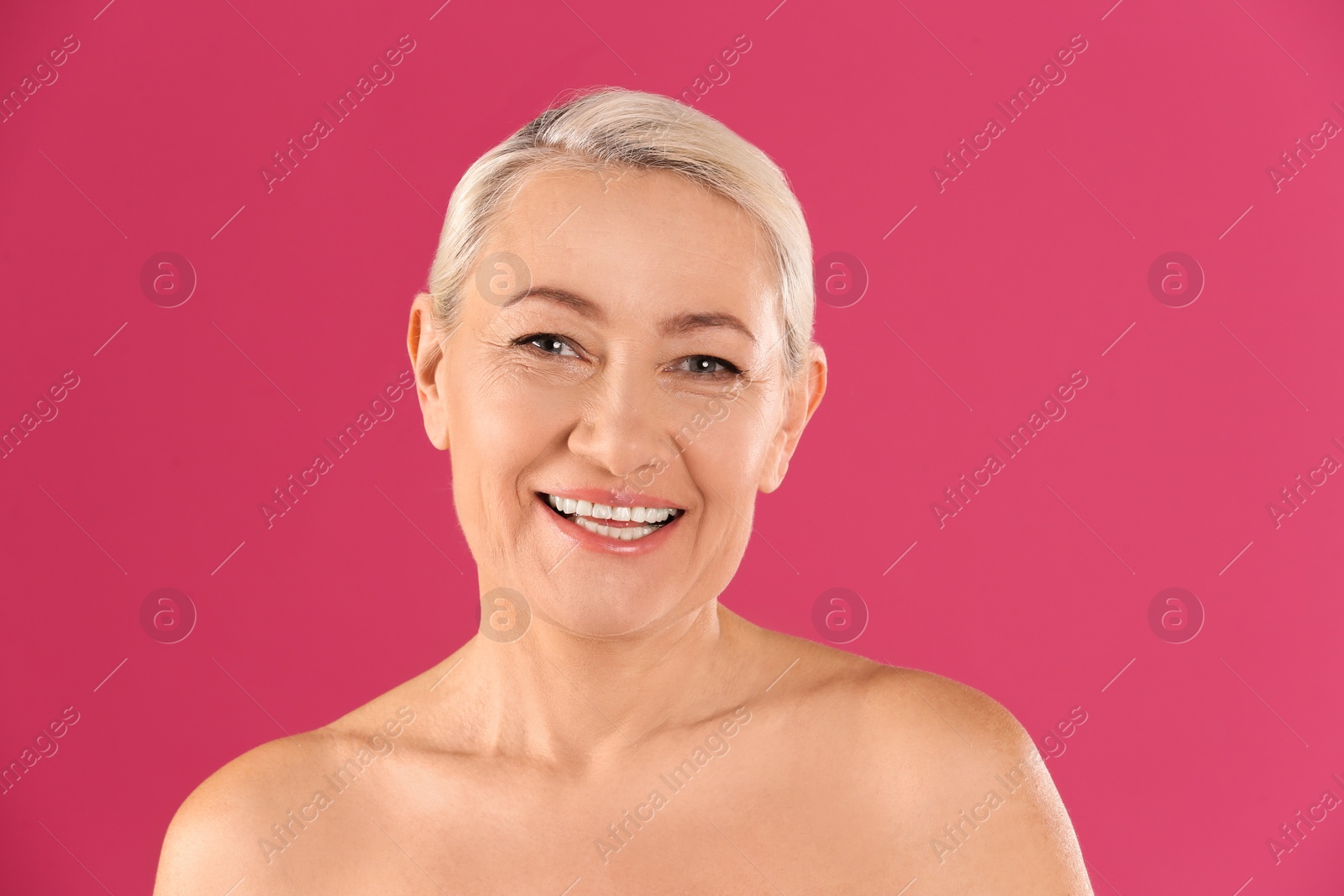 Photo of Portrait of beautiful mature woman on pink background