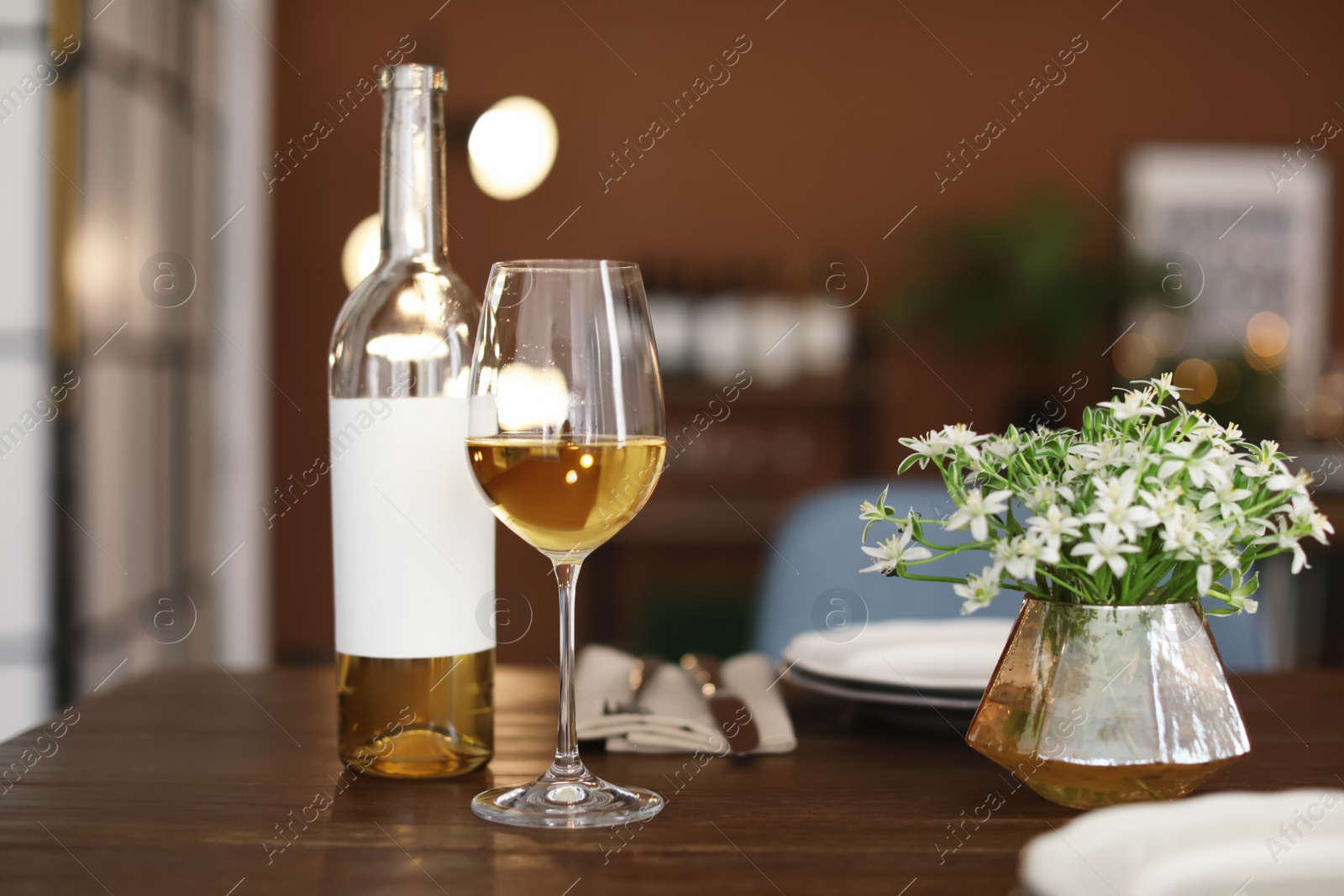 Photo of Glass and bottle of wine on table in restaurant