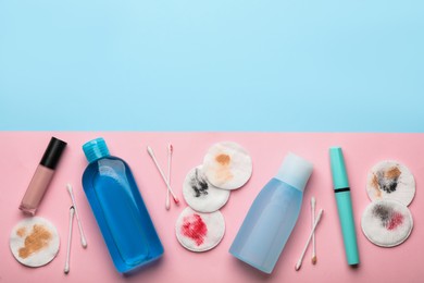 Photo of Dirty cotton pads, swabs, cosmetics and makeup removal products on color background, flat lay. Space for text