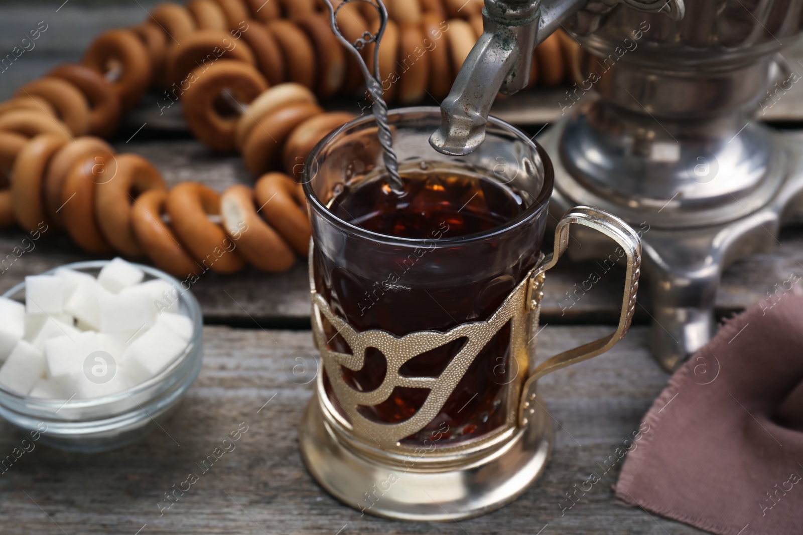 Photo of Cup of tea with delicious ring shaped Sushki (dry bagels) on wooden table
