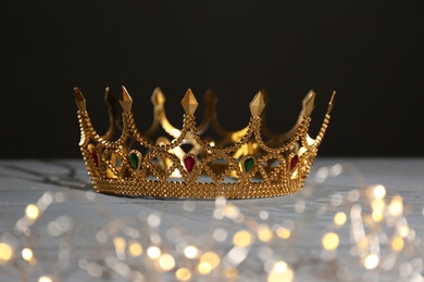 Beautiful golden crown and fairy lights on black background. Fantasy item