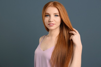 Photo of Portrait of young model with beautiful  hair on grey background