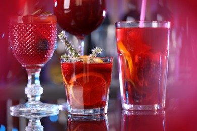 Photo of Many glasses of delicious refreshing sangria on counter in bar, closeup