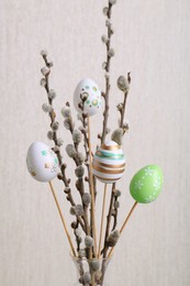 Beautiful willow branches with painted eggs on light grey background. Easter decor