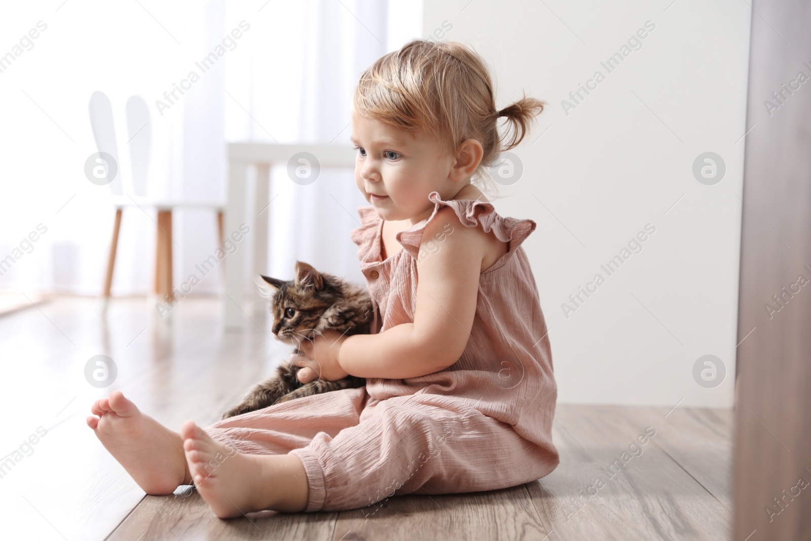 Photo of Cute little child with adorable pet on floor at home