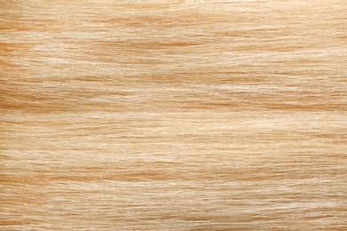 Texture of healthy blond hair as background, closeup