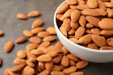 Tasty organic almond nuts in bowl on table