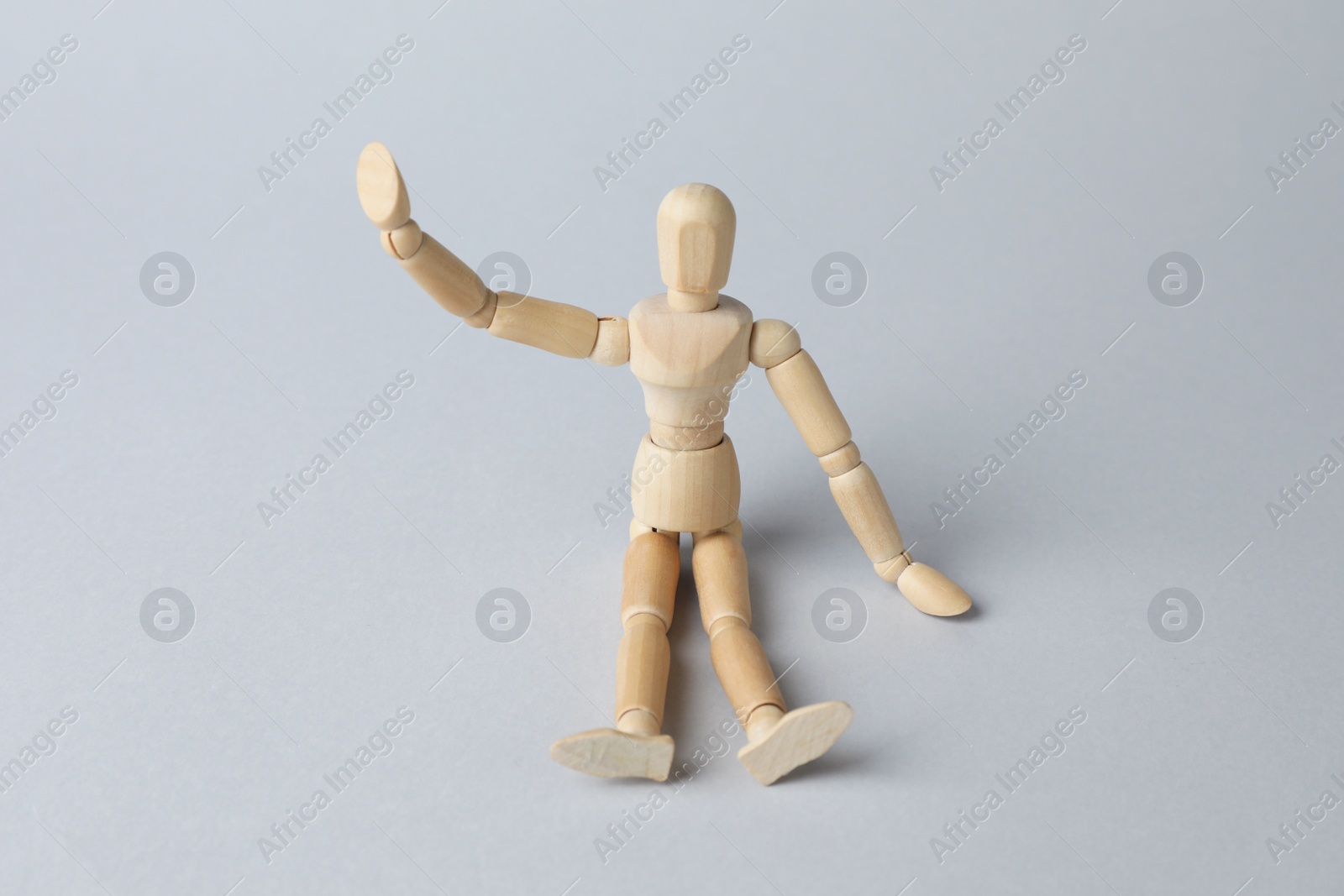 Photo of Wooden human model on grey background. Mini mannequin