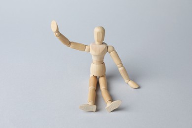 Wooden human model on grey background. Mini mannequin