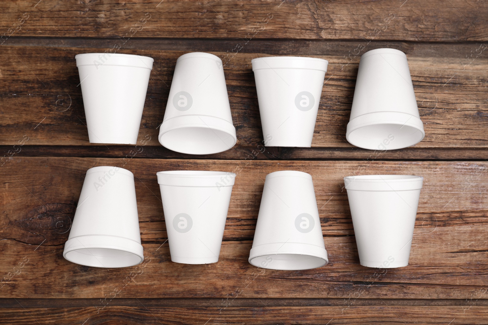 Photo of Many white styrofoam cups on wooden table, flat lay