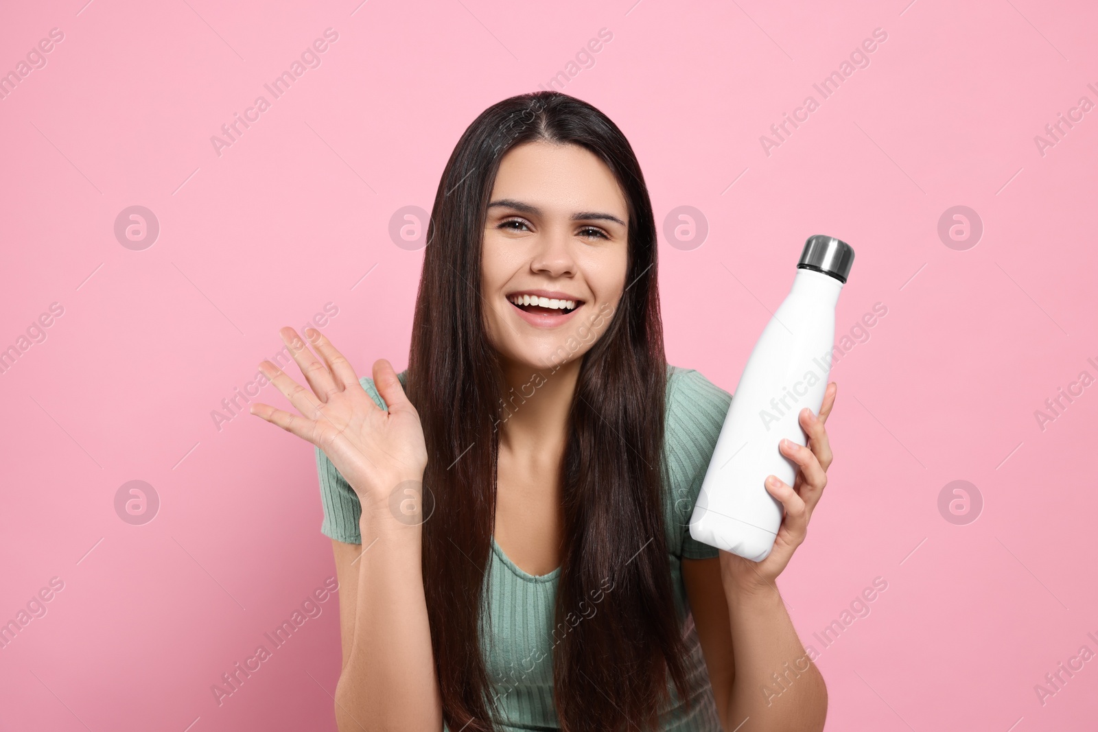 Photo of Young woman with thermo bottle on pink background