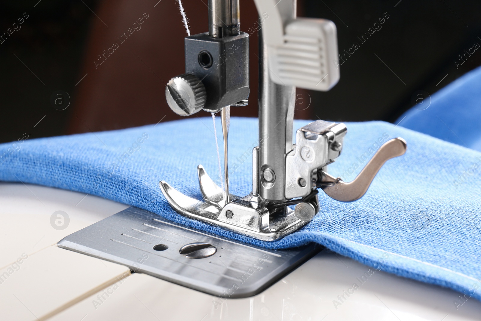 Photo of Sewing machine with light blue cloth, closeup