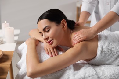 Photo of Beautiful woman receiving back massage in beauty salon, closeup