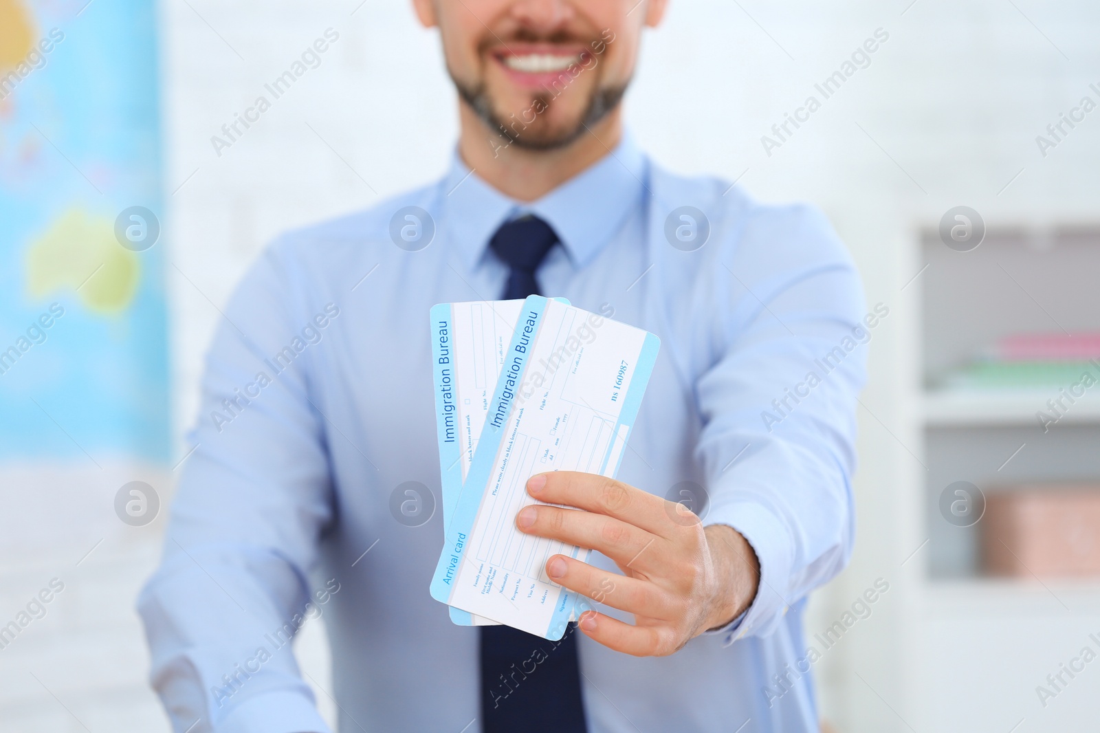 Photo of Male consultant holding tickets in travel agency, closeup