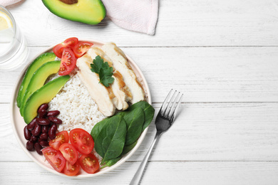 Photo of Delicious rice with beans and meat served on white wooden table, flat lay