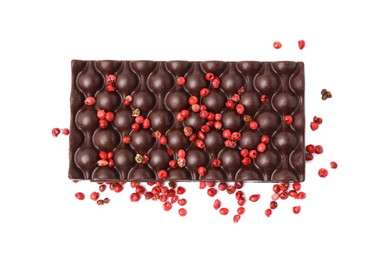 Photo of Dark chocolate bar with red peppercorns isolated on white, top view
