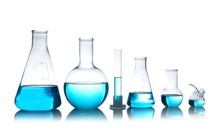 Photo of Laboratory glassware for chemical analysis with blue liquid on table against white background