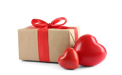 Beautiful gift box with red bow and decorative hearts on white background