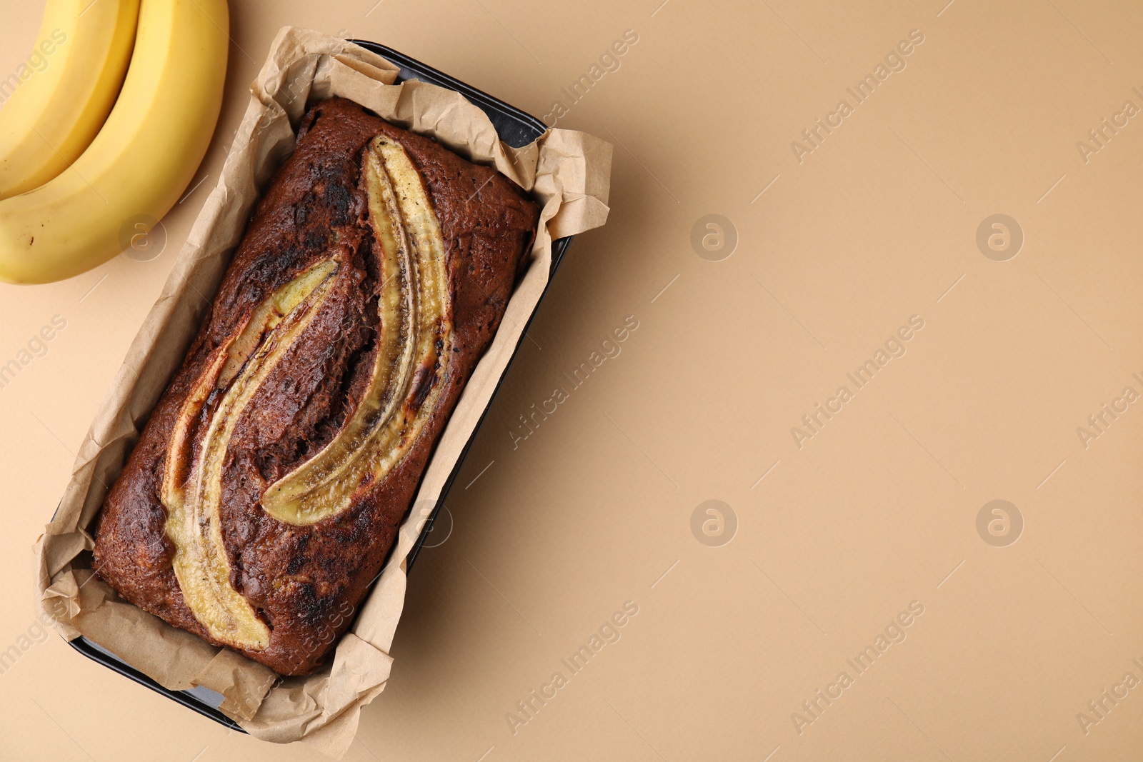 Photo of Delicious banana bread on beige background, top view. Space for text