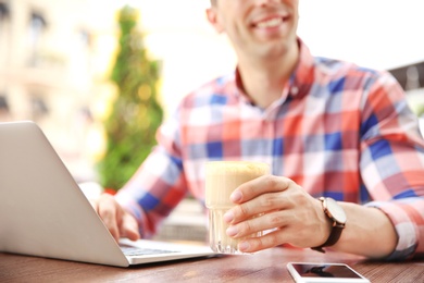 Young man working with laptop at desk, closeup