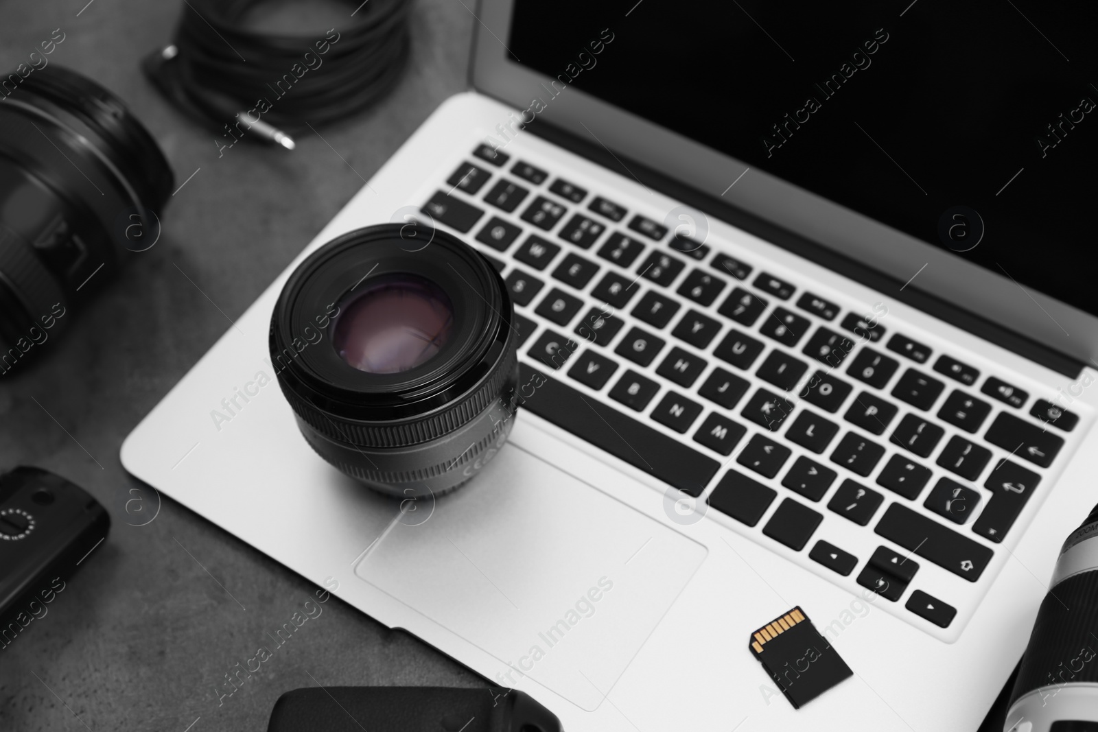 Photo of Professional photographer equipment and laptop on table