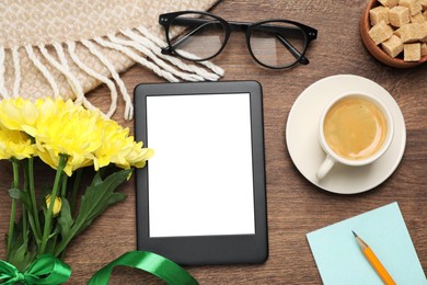 Photo of Flat lay composition with e-book reader, cup of coffee and flowers on wooden table. Space for text