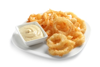 Photo of Plate with delicious crispy onion rings and sauce on white background