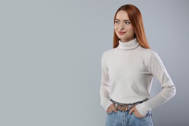 Portrait of beautiful young woman on light gray background, space for text