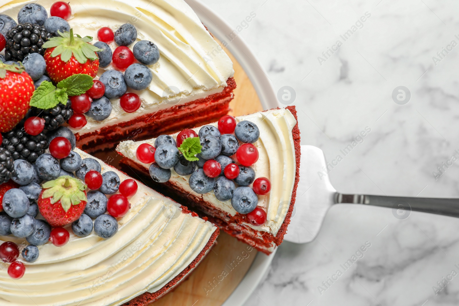 Photo of Delicious homemade red velvet cake with fresh berries on table, top view