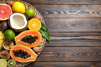 Photo of Fresh ripe papaya and other fruits on wooden table, top view. Space for text