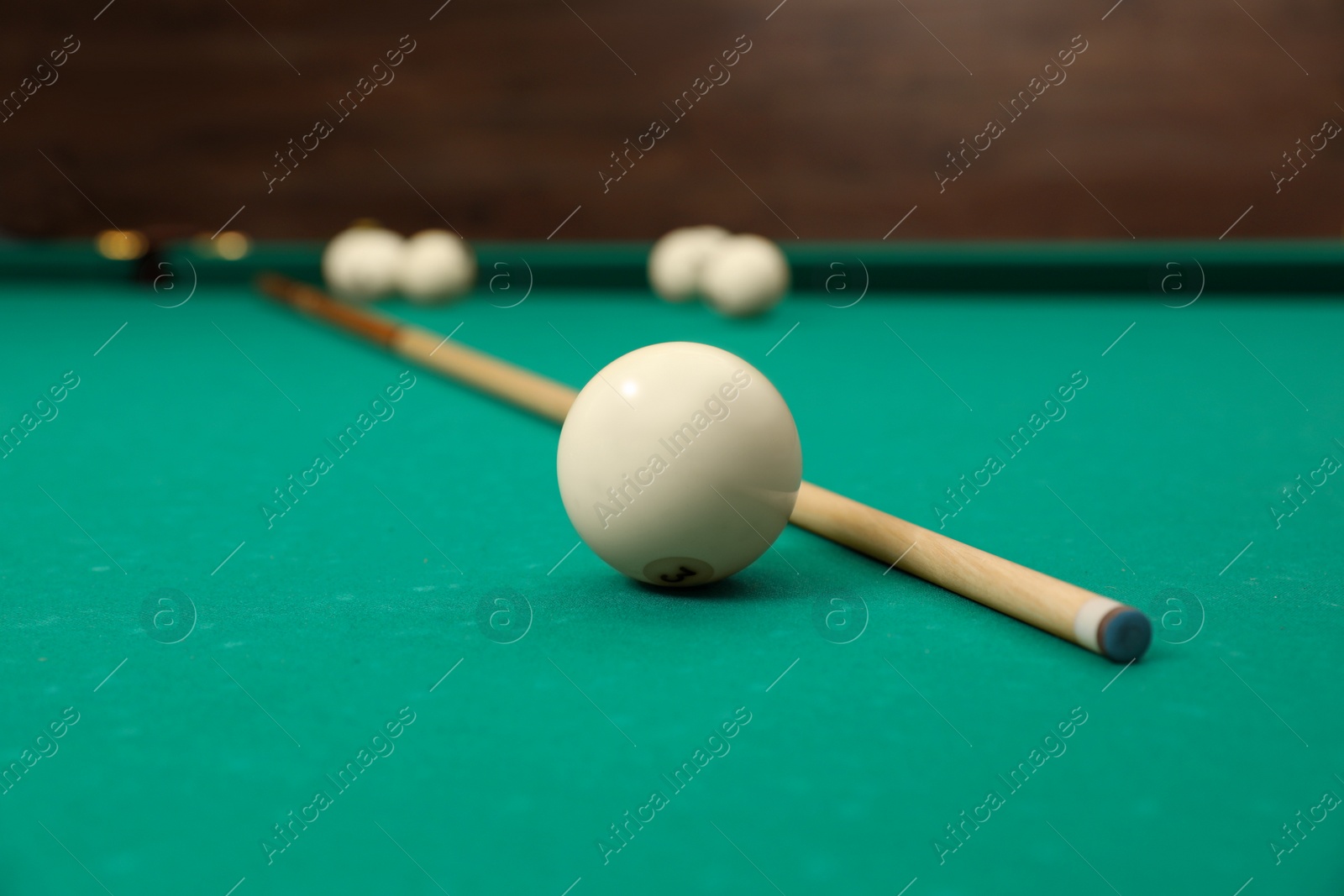 Photo of Billiard balls and cue on table indoors