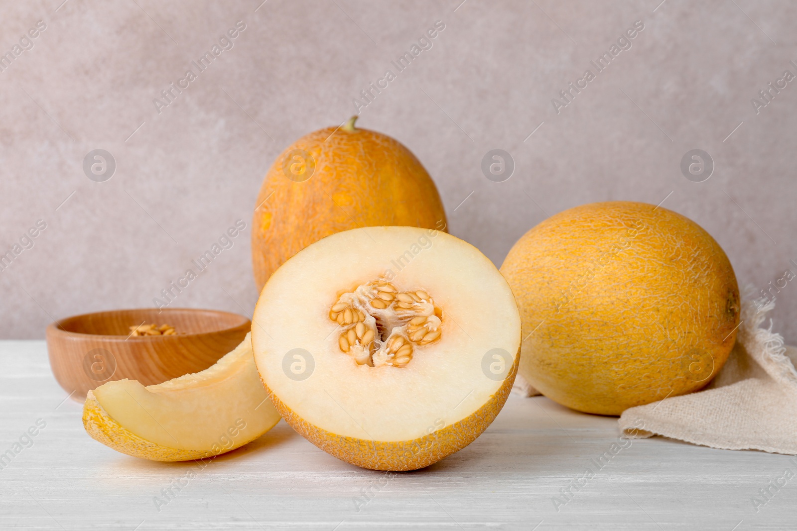 Photo of Fresh delicious sweet melons on table against color background