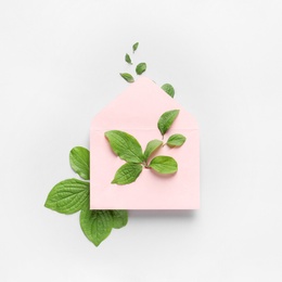 Photo of Composition with green leaves and envelope on light background, top view