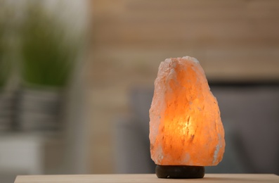 Himalayan salt lamp on table against blurred background