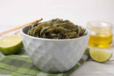 Photo of Tasty seaweed salad in bowl served on table, closeup